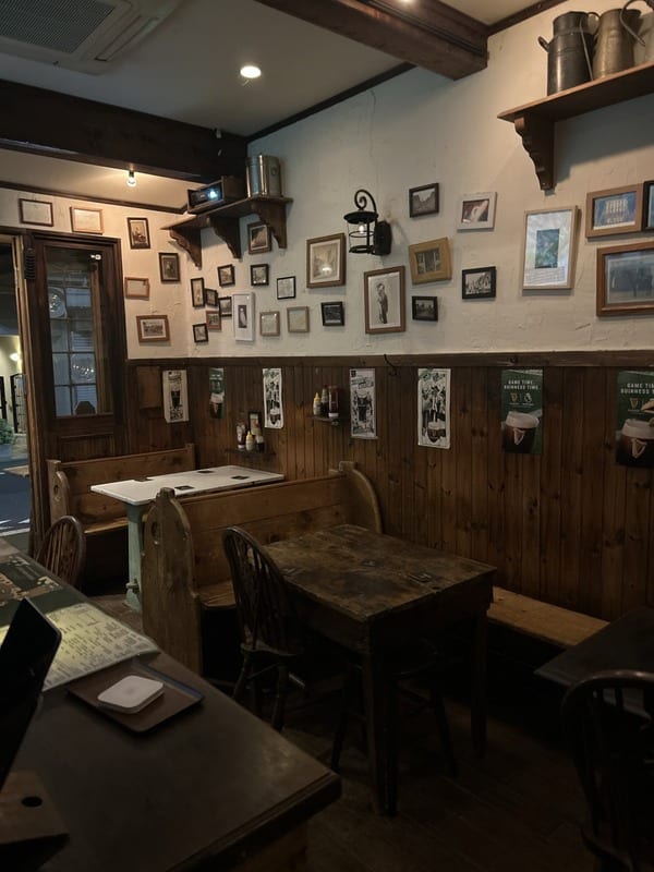 壁一面の額縁と木のベンチが並ぶ店内のダイニング。